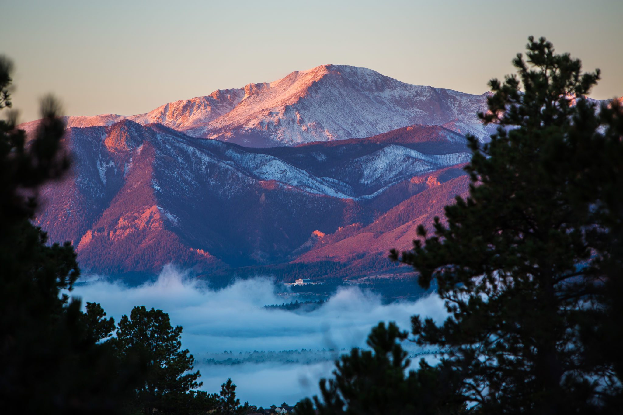 Pikes Peak mountain with mist in purple and blue light.