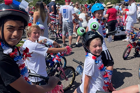 Kids on bikes at a Fourth of July celebration.